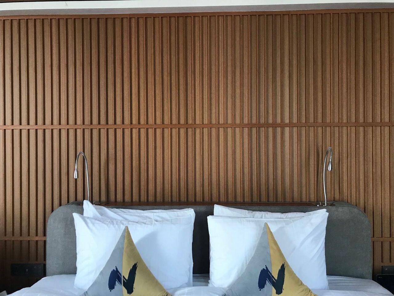 Plush pillows with elegant wooden headboard in a Dongdaemun Novotel Ambassador Hotel room.